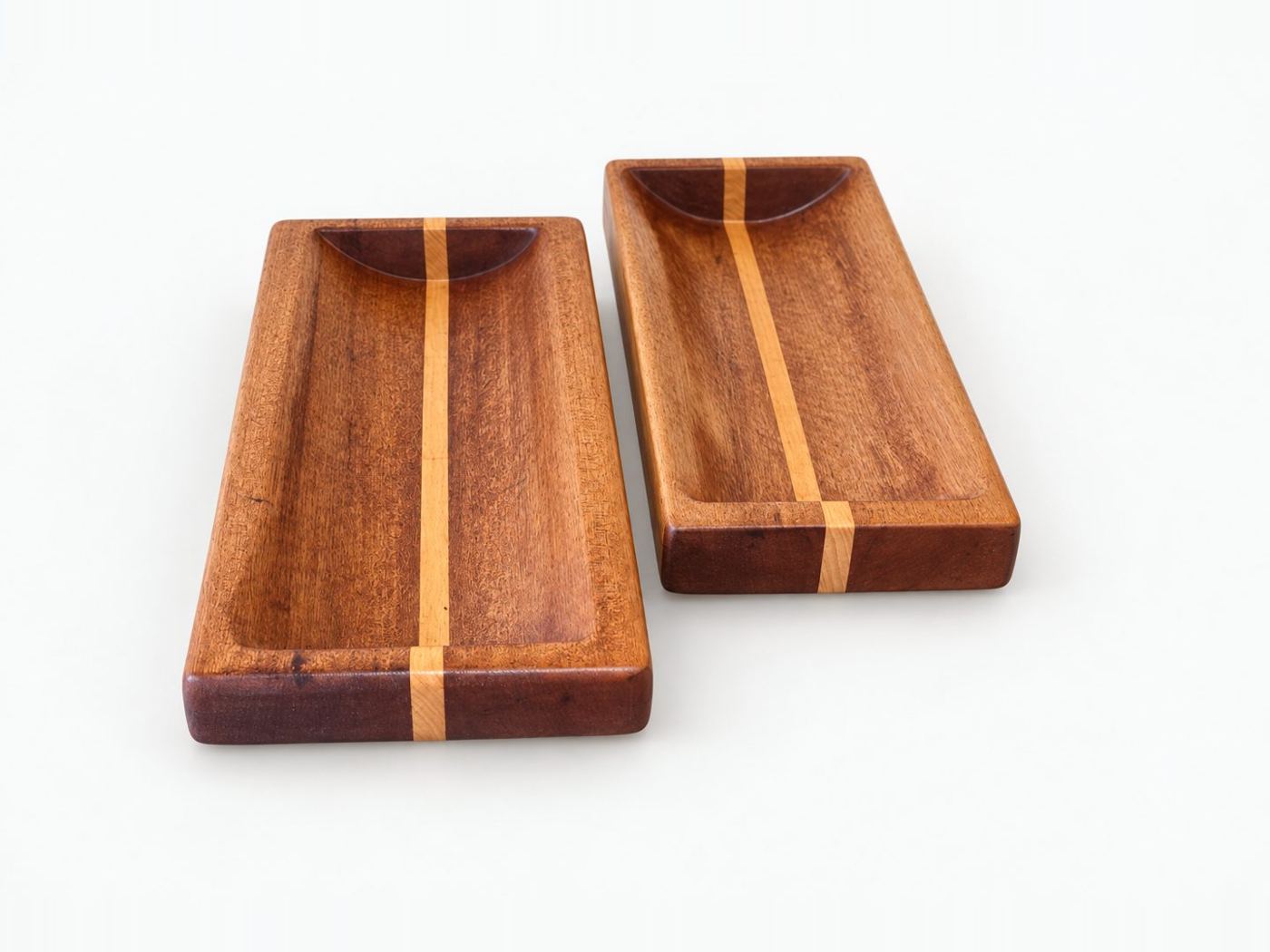 Two kiaat serving trays with a pale inlaid stripe and a recessed well