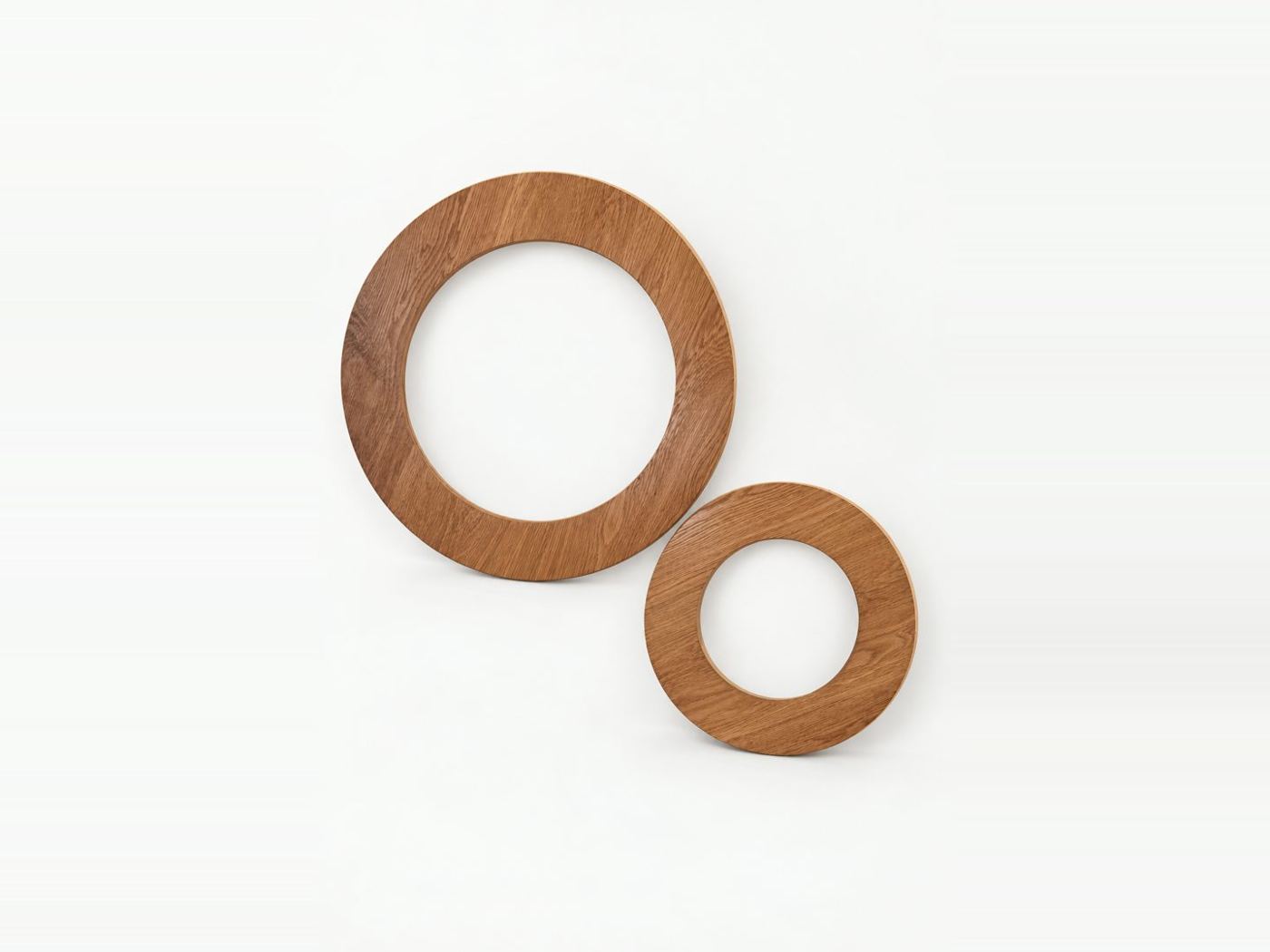 Two round oak framed mirrors in different sizes